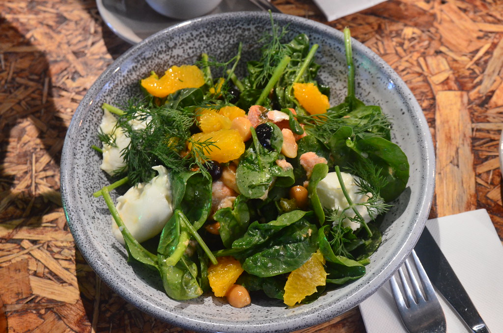 A vibrant Burrata salad topped with fresh greens, colorful tomatoes, and drizzled with a balsamic reduction