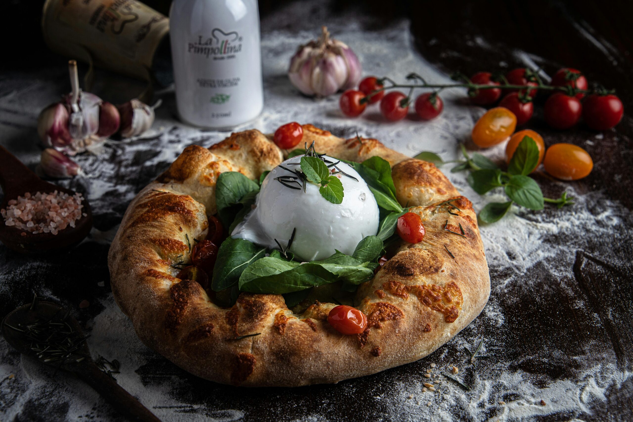 Assorted gourmet dishes featuring creamy burrata cheese, including pizzas, salads, and pasta, beautifully presented on elegant dining ware