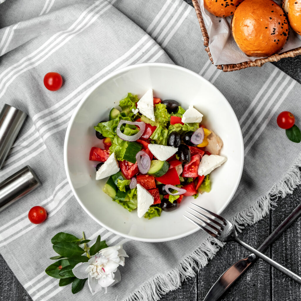 A variety of burrata appetizers beautifully arranged on a rustic wooden table, featuring seasonal fruits and vegetables.