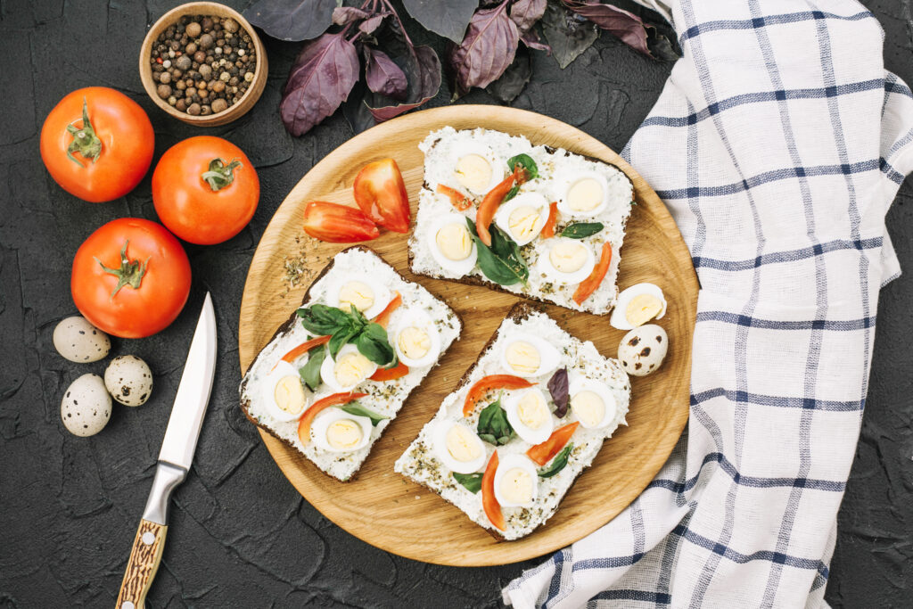 Elegant burrata appetizer with heirloom tomatoes and fresh basil on a rustic wooden board.